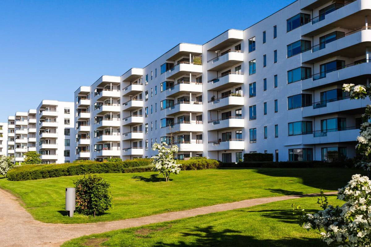 Condominio moderno con giardino verde e sentiero pedonale.
