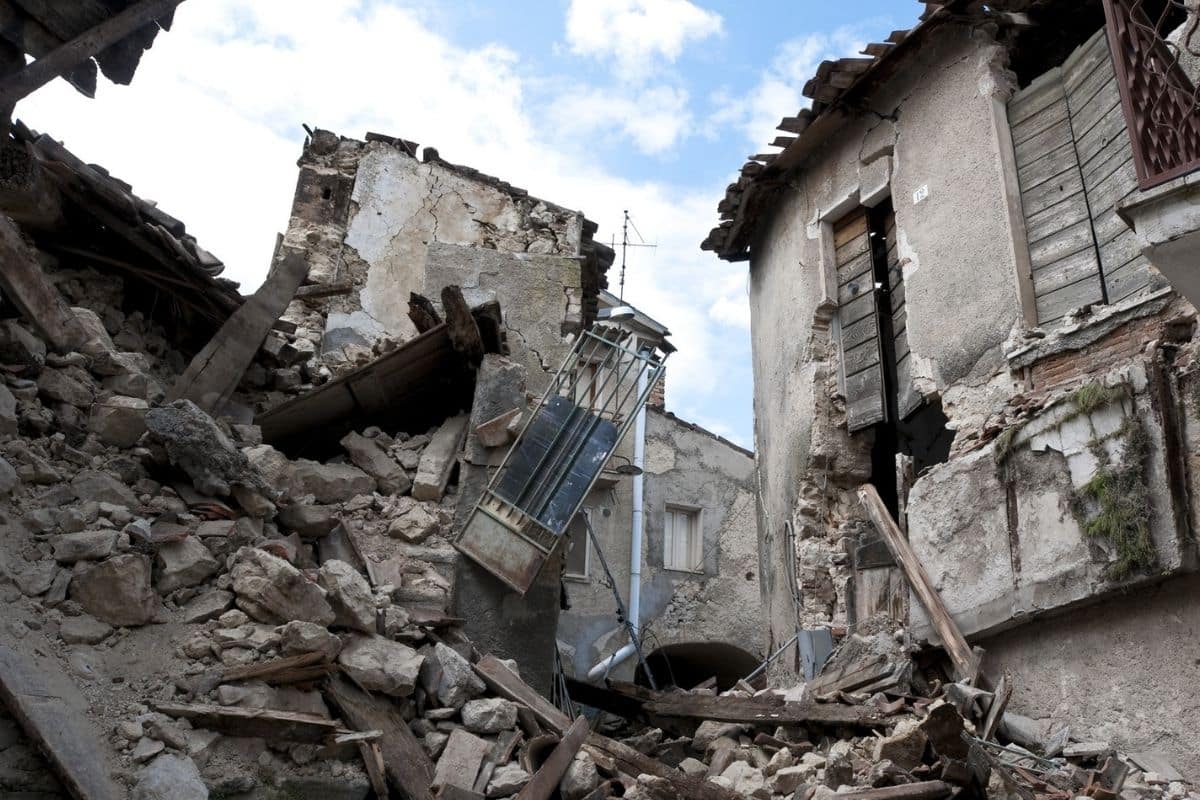 Danni causati da un terremoto in un villaggio, macerie e distruzione.