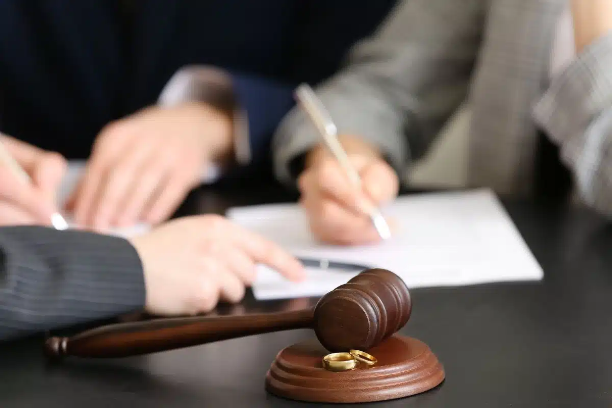 Giudice e avvocati al lavoro su documenti legali con martelletto.