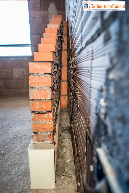 Isolamento termico edificio con muro a intercapedine. Mattoni rossi e vuoto per maggiore efficienza.