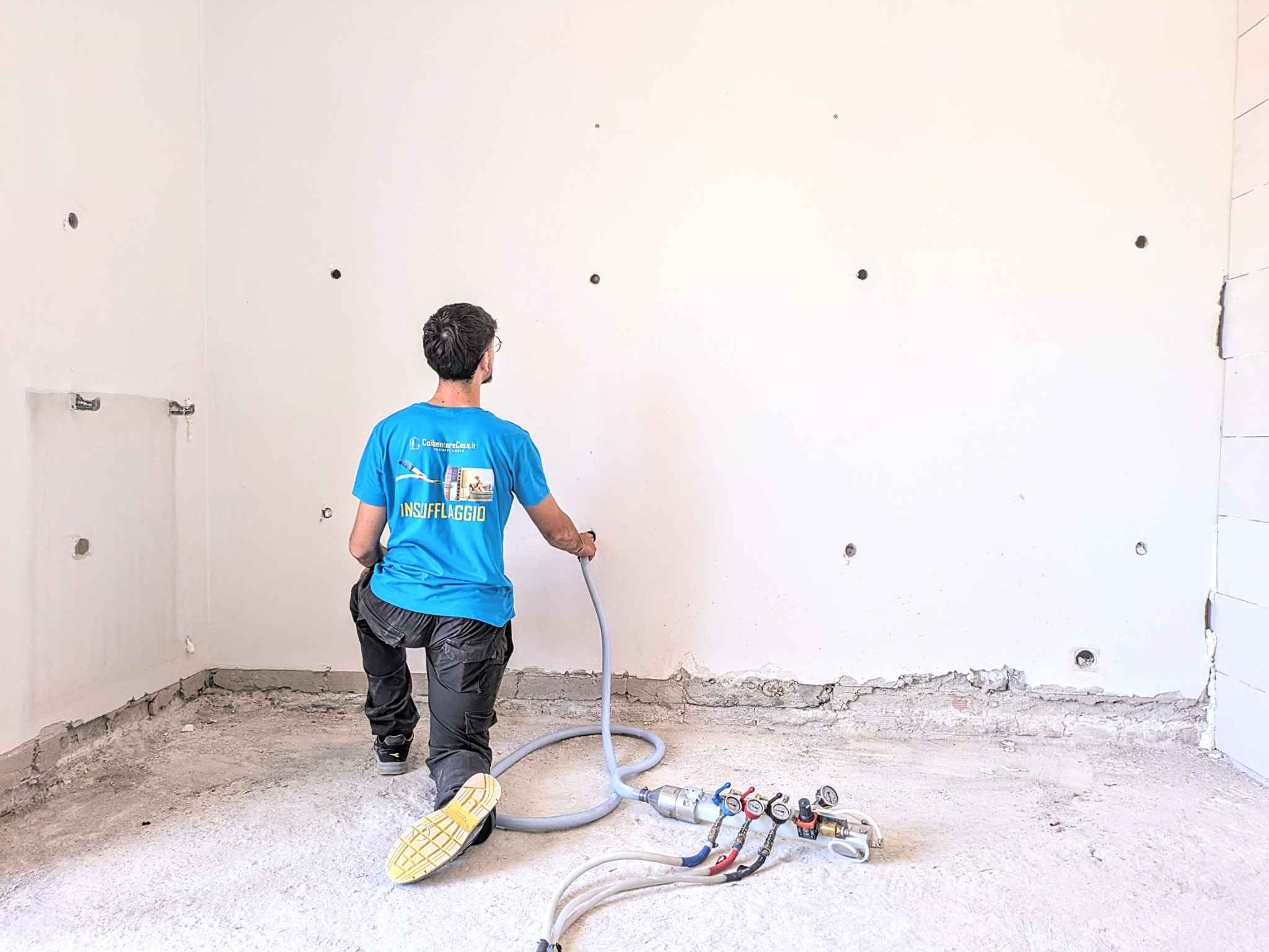 Momento operativo dell’insufflaggio con schiuma espansa ISOFOR: il tecnico procede all’iniezione nella parete perimetrale.