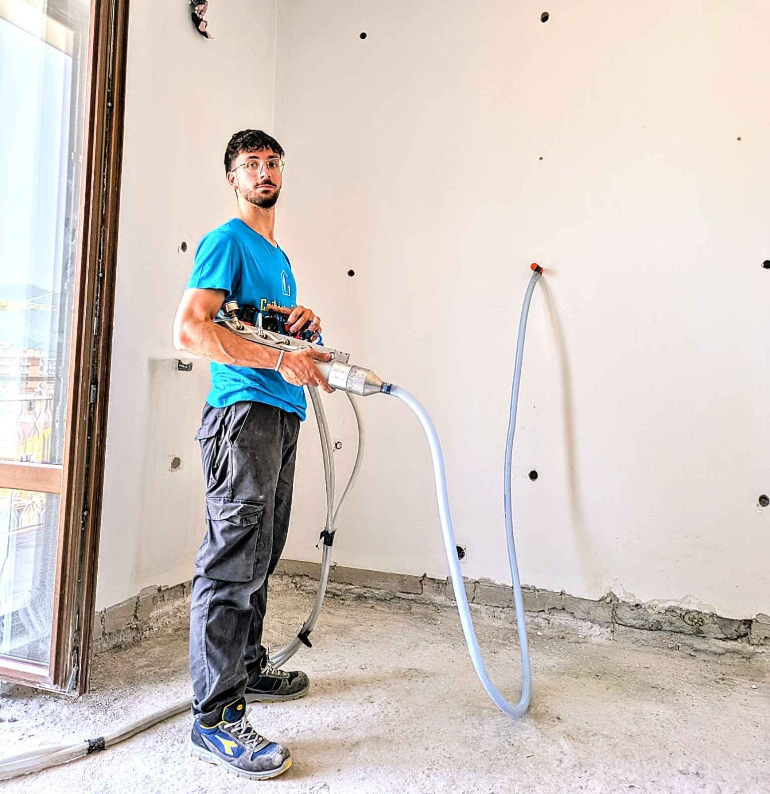 Insufflaggio in corso su parete esterna: l’operatore introduce la schiuma isolante ISOFOR all’interno dell’intercapedine.