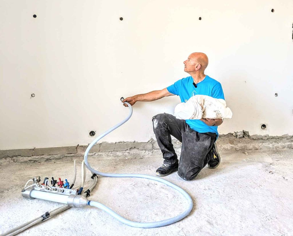 Tecnico durante insufflaggio termico mostra la schiuma espansa ISOFOR, utilizzata per riempire le cavità dei muri esterni.