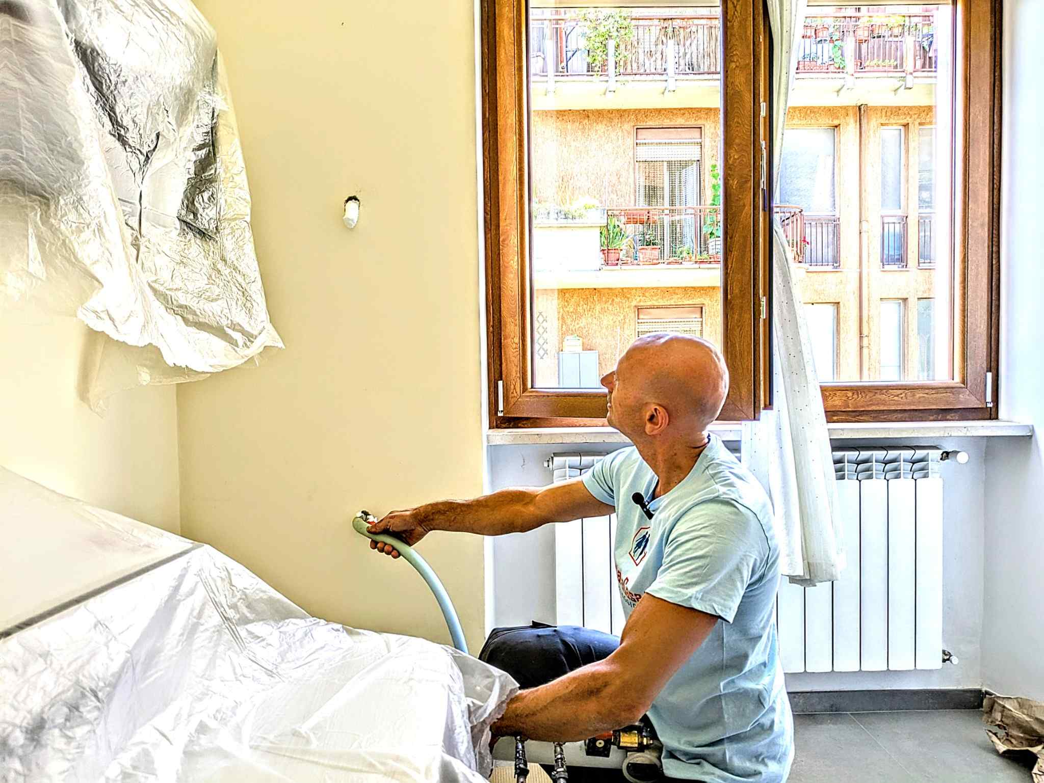Iniezione manuale della schiuma isolante con operatore inginocchiato