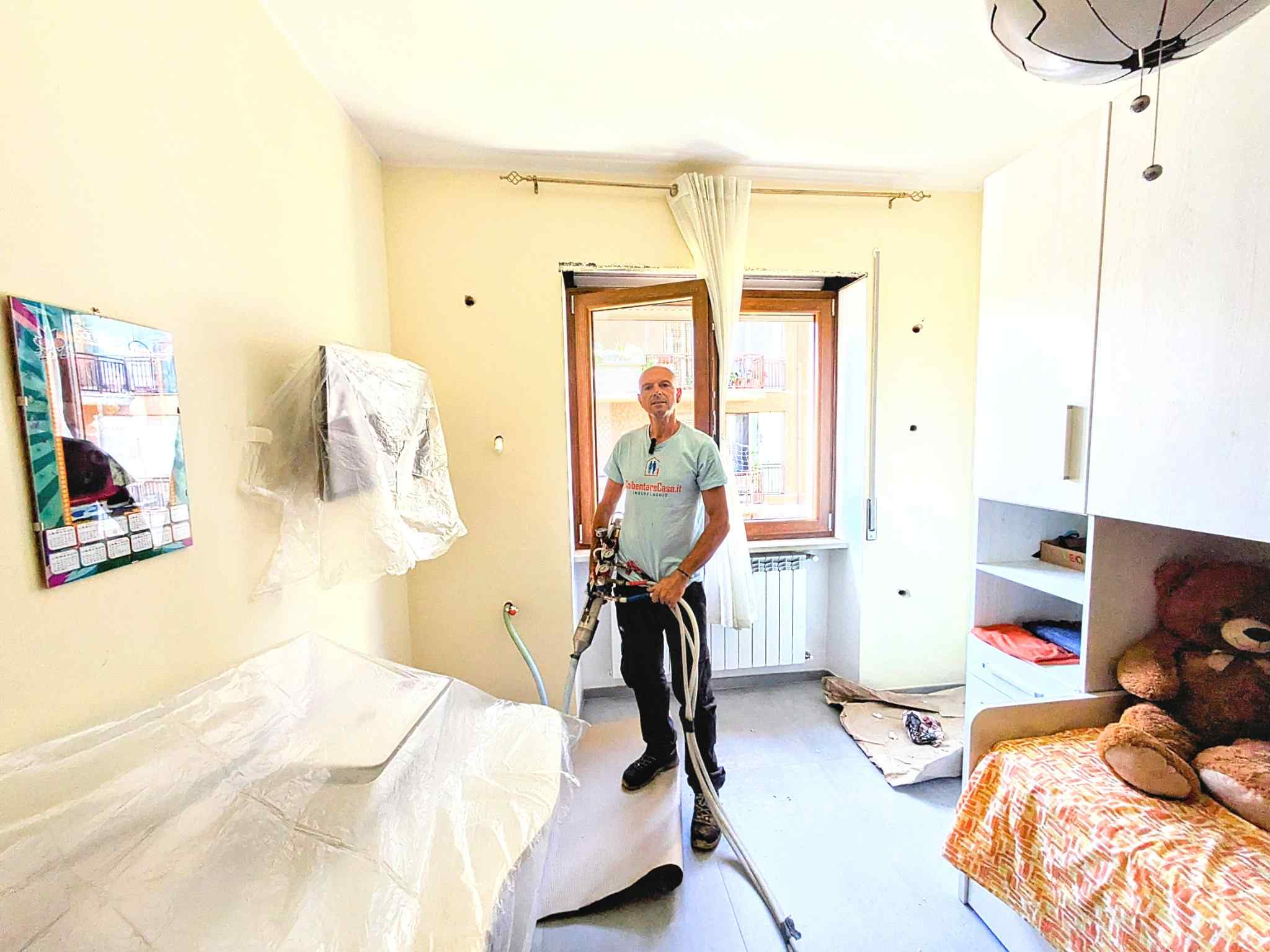 Tecnico esegue foratura verticale per insufflaggio in ambiente luminoso.