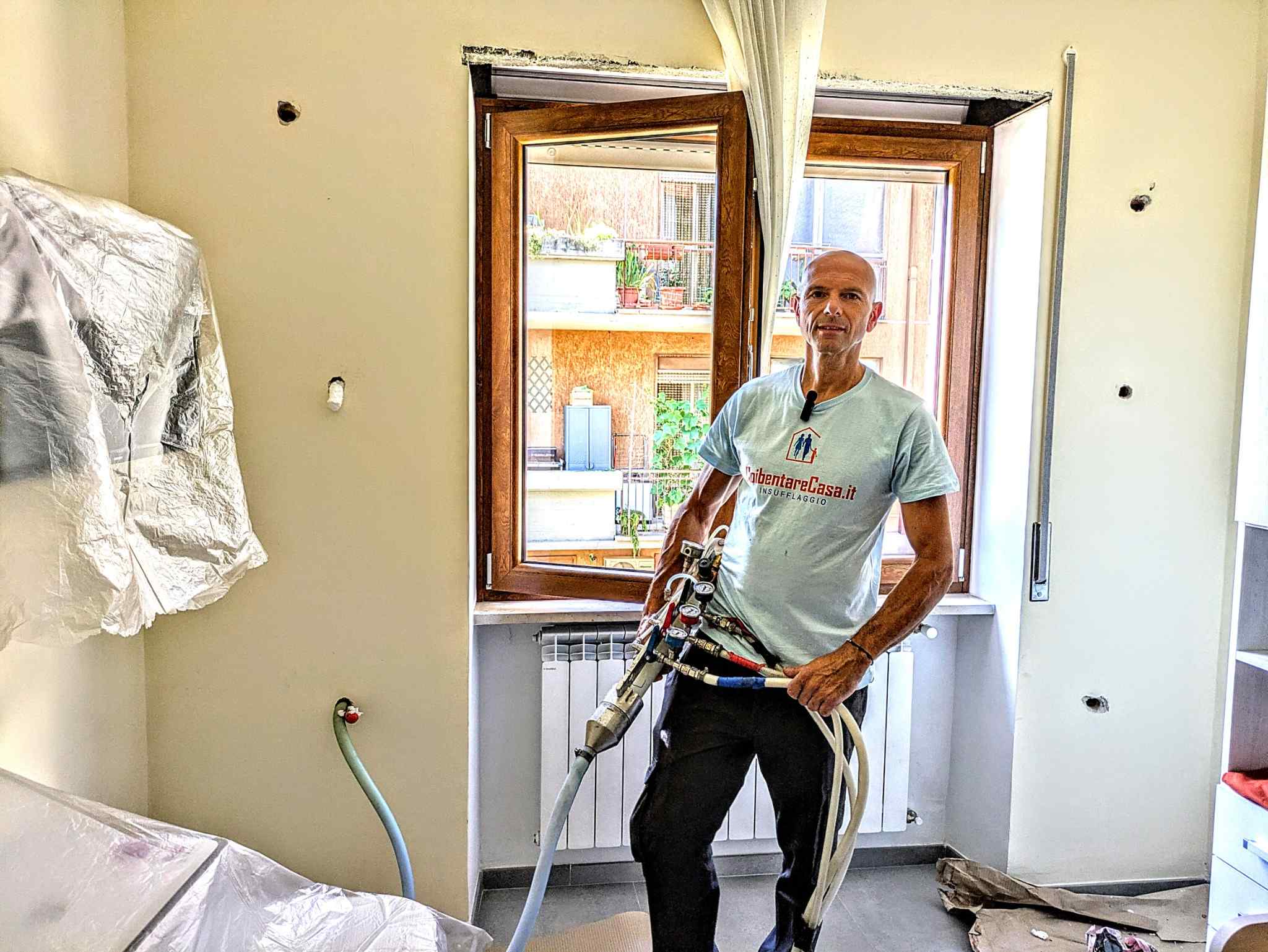 Tecnico inizia il riempimento delle intercapedini con schiuma ISOFOR in una cameretta.