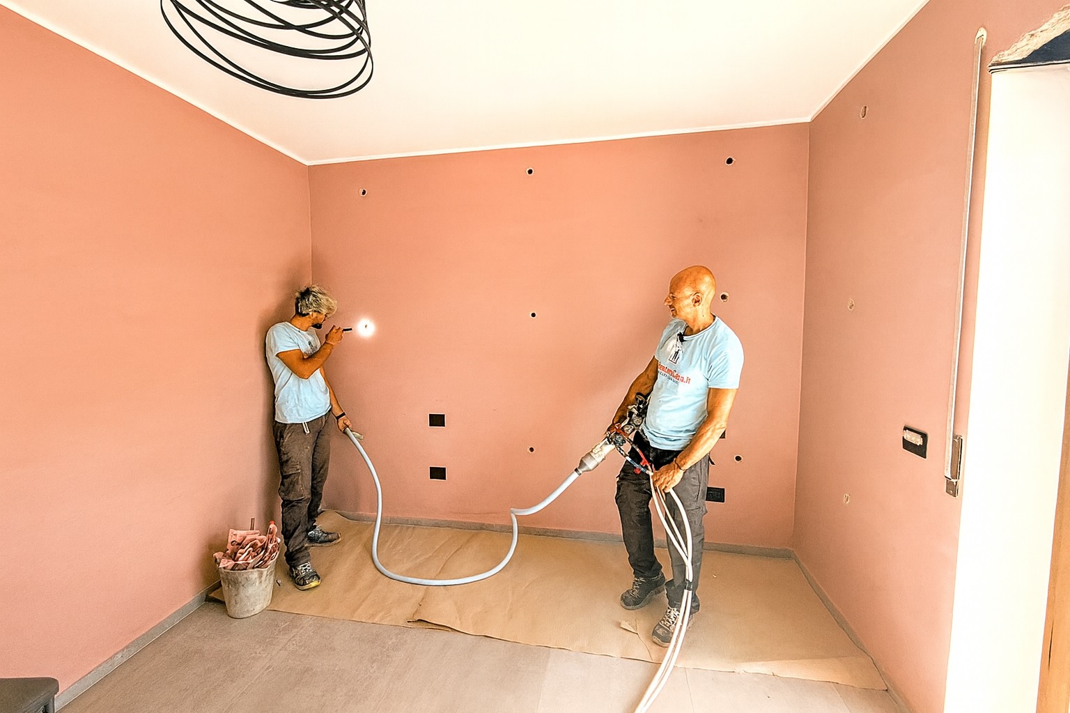 Insufflaggio schiuma isolante: operai al lavoro. Foratura pareti per isolamento termico con schiuma poliuretanica.